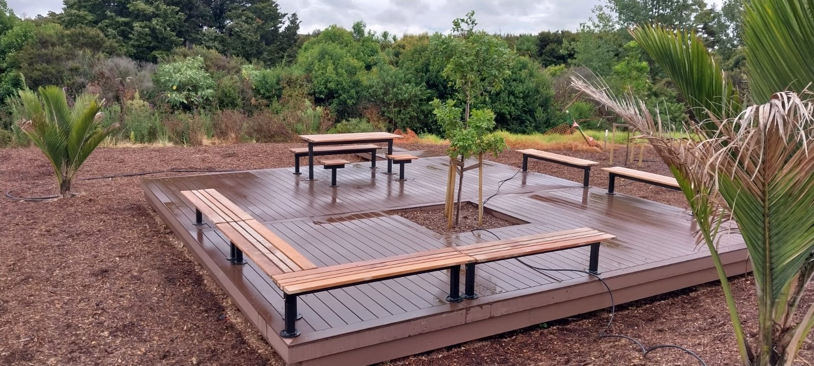 Large composite entertaining deck with built-in seating and tables in Auckland