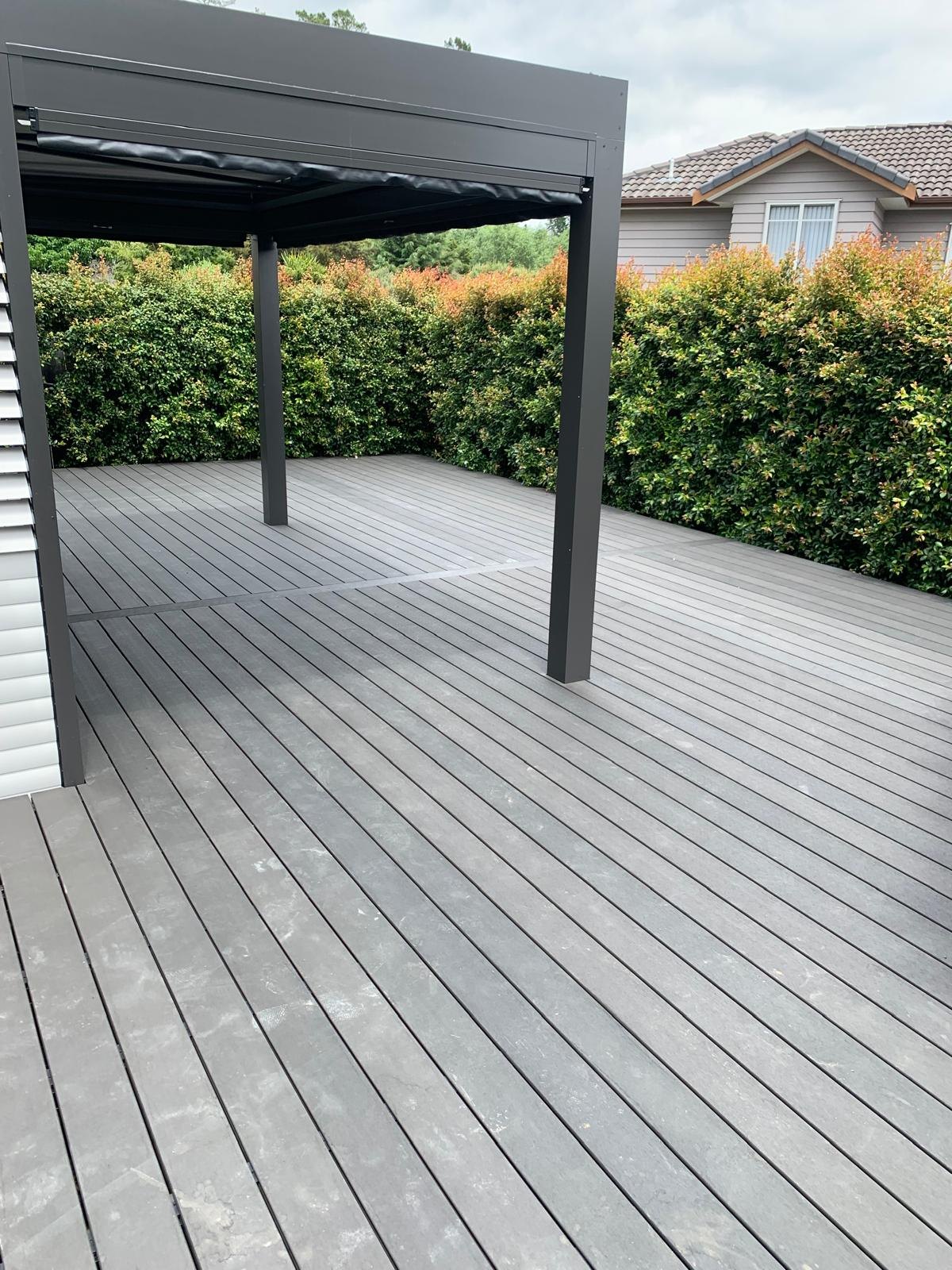 Dark contemporary louvred pergola installed over a large grey deck