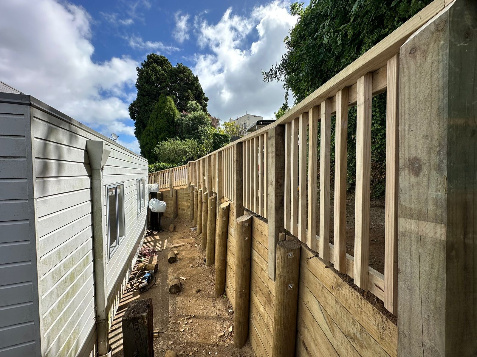 Timber garden retaining wall and fence following a residential boundary