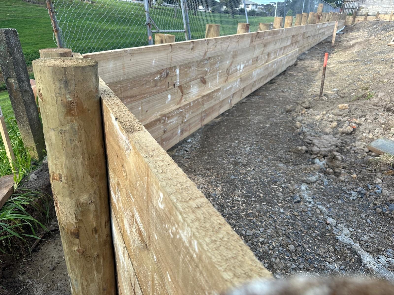 Heavy timber retaining wall structure defining a residential landscape area