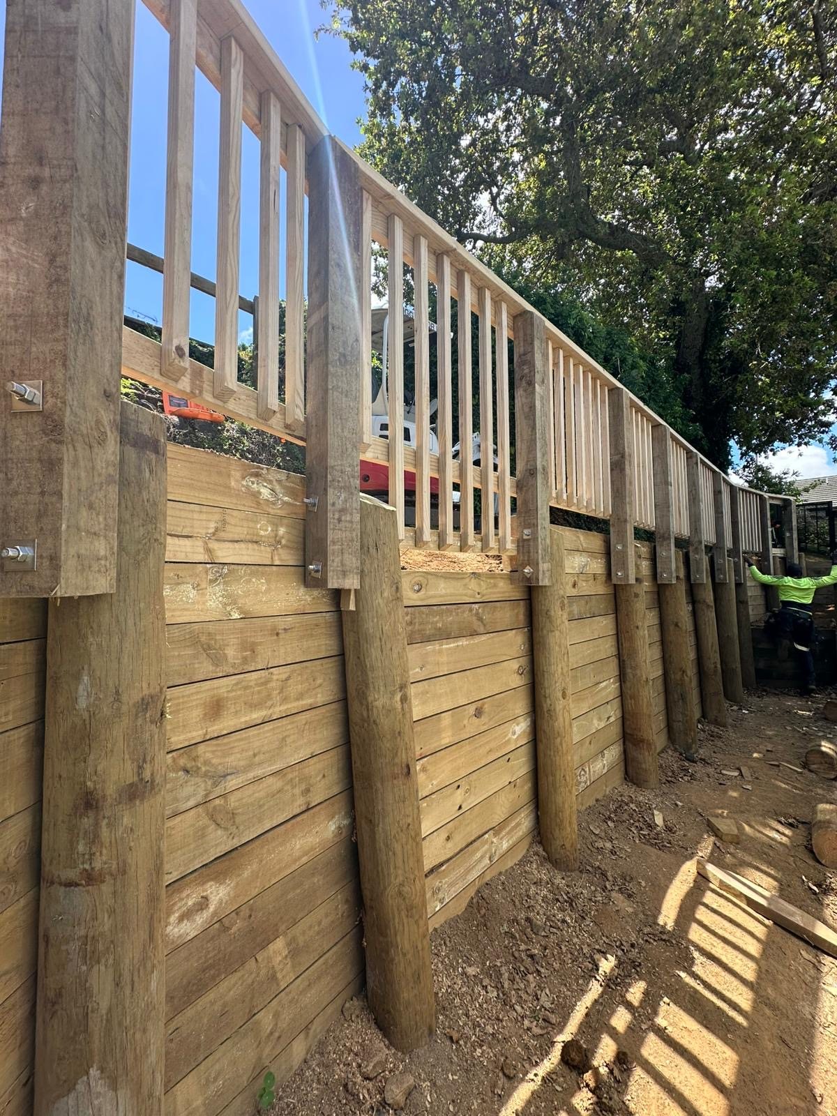 Timber retaining wall constructed alongside an elevated deck